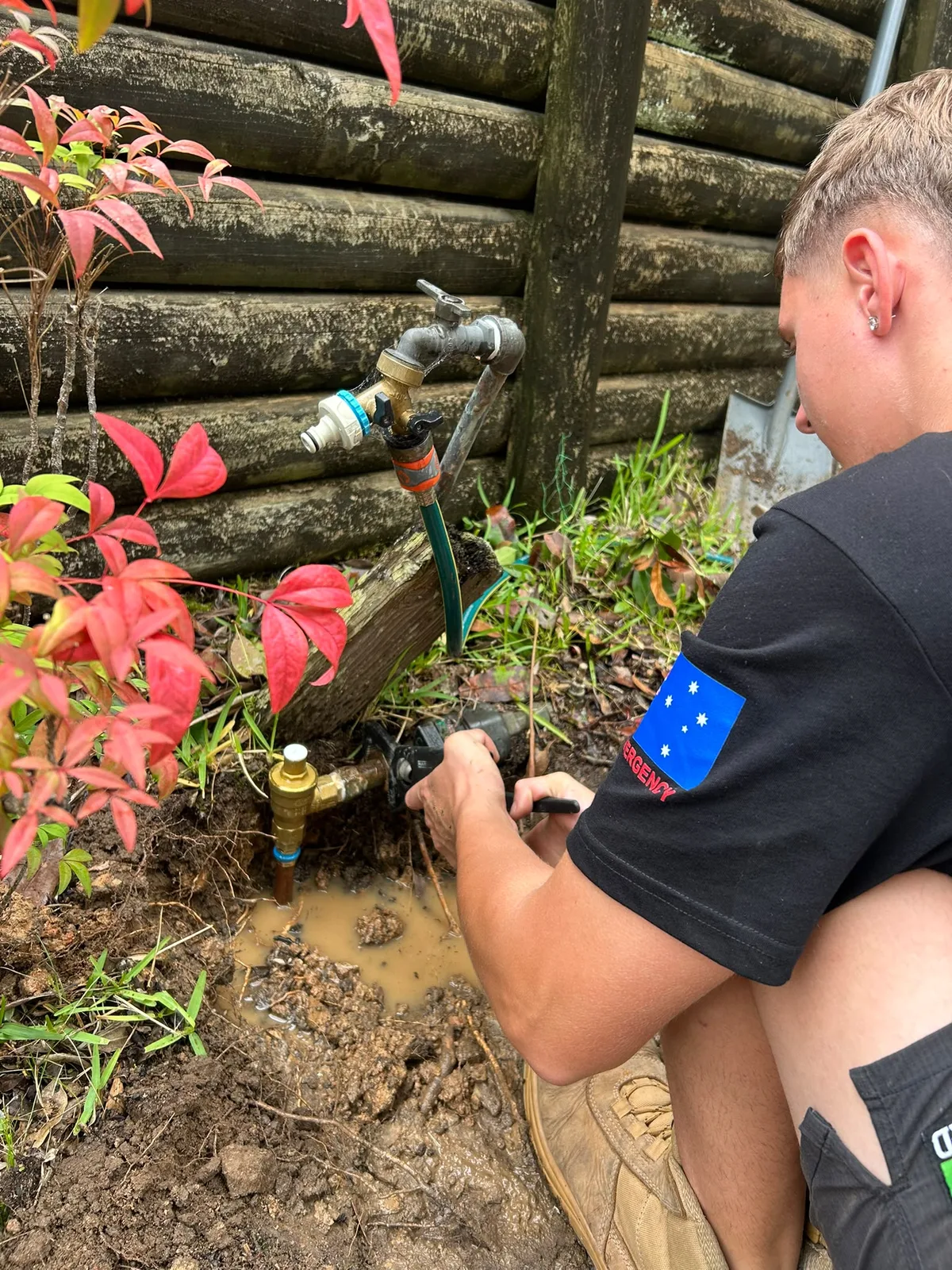 A plumber working at a garden tap fitting